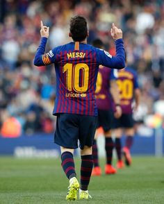 a soccer player is walking on the field with his hands in the air as he celebrates