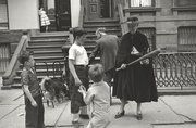 an old black and white photo of people on the sidewalk