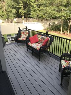 two wicker chairs sitting on top of a wooden deck