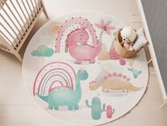 a child's rug with dinosaurs and rainbows on the floor next to a crib