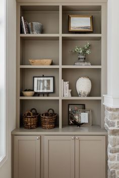 an empty bookcase with pictures and baskets on the top, along with other items