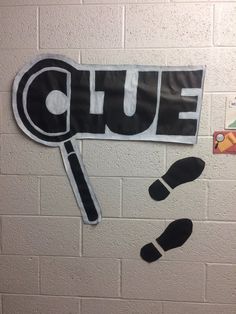 a bulletin board with a magnifying glass on it next to a foot print