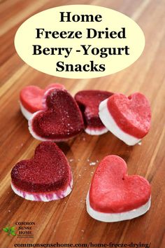 some heart shaped treats sitting on top of a wooden table with the words home freeze drying berry - yogurt snacks