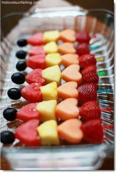 fruit skewers are arranged in the shape of hearts