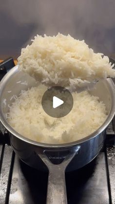 rice is being cooked in a pot on the stove top with a ladle over it