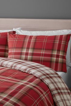 a red plaid comforter and pillows on a bed