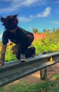 a person on a metal rail with grass and trees in the background