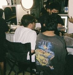 a group of young men sitting around a computer desk