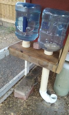 two plastic water bottles sitting on top of a wooden stand