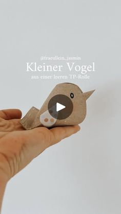 a person is holding a small bird made out of brown paper with the words kleener vogel on it