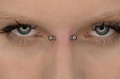 a woman's eyes with piercings on them