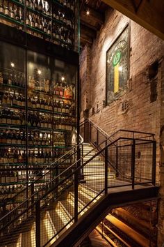 a staircase leading to a wine cellar with lots of bottles on the walls and shelves