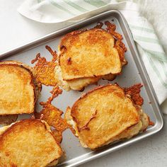 four grilled cheese sandwiches on a baking sheet