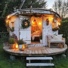 a small white shed with lights on the roof and doors open to let in some light