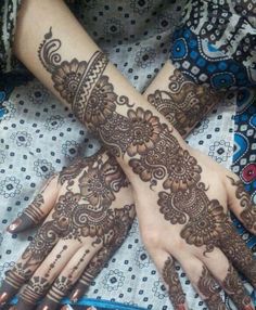 two hands with henna tattoos on them