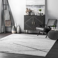 a living room area with a rug, chair and painting on the wall in it