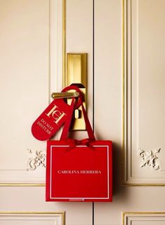 a red bag hanging from the side of a door with a gold lock on it