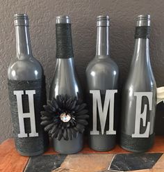 three bottles with the word home painted on them