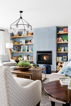 a living room filled with furniture and a fire place in the middle of a room