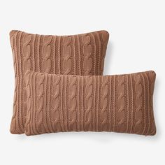 two brown knitted pillows sitting on top of each other