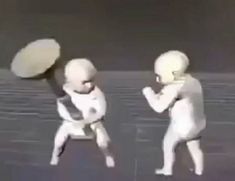 two babies are playing with frisbees on the beach in black and white