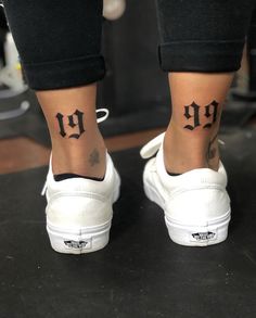 a woman's foot with a small tattoo on her left ankle and the word up written in cursive letters