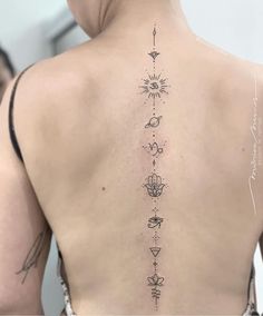 the back of a woman's body with tattoos on her upper and lower back