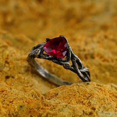 a close up of a ring with a heart shaped stone on it's side