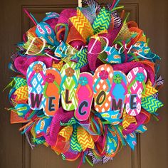 a colorful wreath with the word welcome on it and some decorations around it that says custom wreath designs