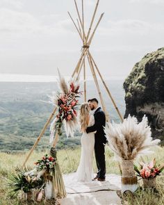 a man and woman standing in front of a teepee