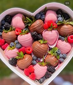 a heart shaped box filled with lots of chocolate covered strawberries and raspberries