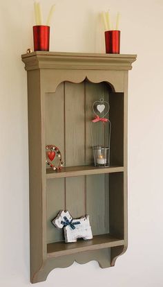 a wooden shelf with two small items on it and the bottom shelf is painted brown