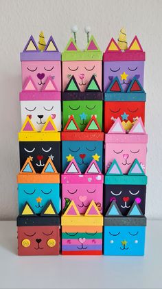 many colorful boxes are stacked on top of each other and have faces painted on them