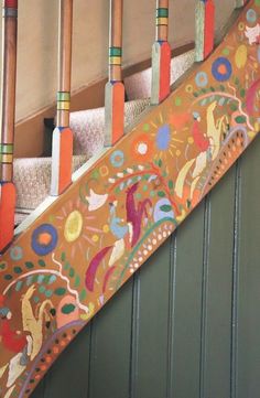 there is a colorful stair case on the side of a building with decorative designs and wooden poles