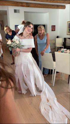 the bride is walking down the aisle with her mother and sister in the back ground