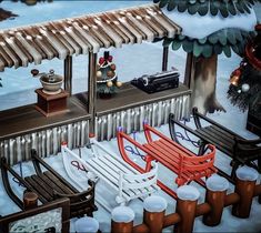 a painting of a snow covered park bench and picnic table in front of a building