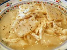 a bowl filled with chicken and gravy on top of a table