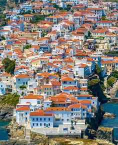 an aerial view of a city with lots of white buildings and red roof tiles on the roofs