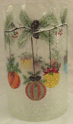 a glass vase with christmas ornaments on it