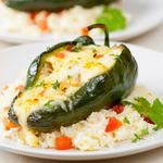 two white plates topped with rice and green peppers