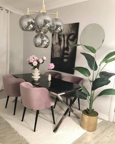 a dining room with pink chairs and a black table