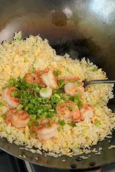 shrimp and rice is being cooked in a wok