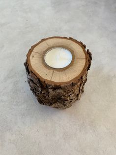 a candle is sitting on top of a piece of wood