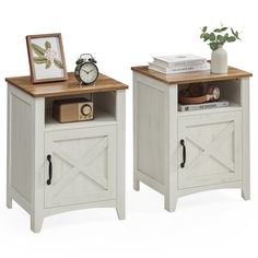 two white nightstands with one open door and the other closed on both sides, side by side