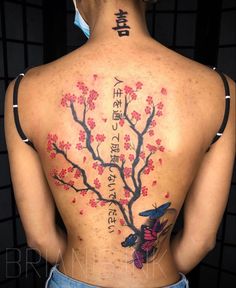 the back of a woman's body with flowers and butterflies painted on her back