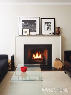 a living room with a fire place and pictures on the fireplace mantel above it