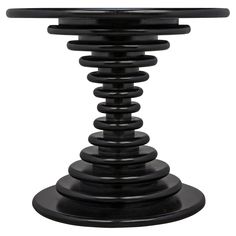 a black table with an oval glass top and spiral design on the base, against a white background