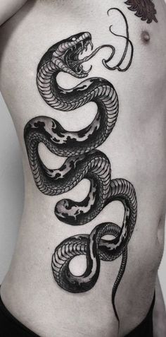 a man with a tattoo on his stomach has a snake tattooed on the side of his body