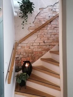 a light that is on the side of a set of stairs next to a brick wall