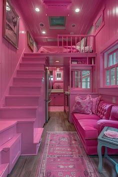 a living room with pink furniture and stairs in the ceiling, along with a rug on the floor